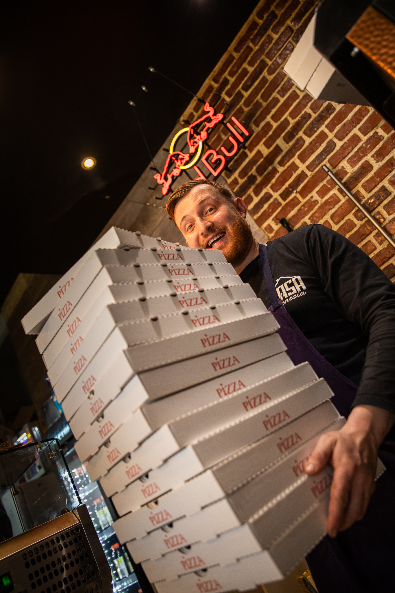 Erwan de Casa Venezia tenant des pizzas